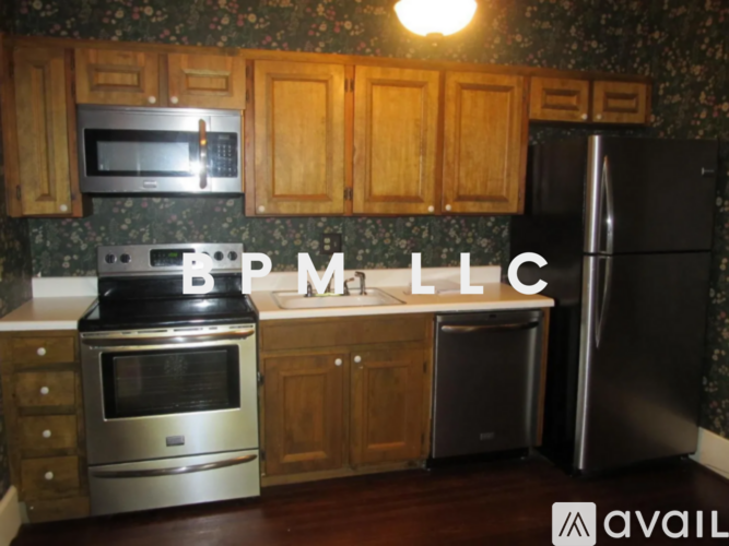 A kitchen with a refrigerator, oven, and microwave.