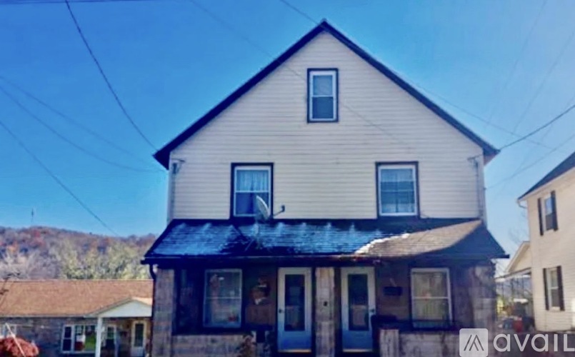 A two-story house with a blue door and a small porch.