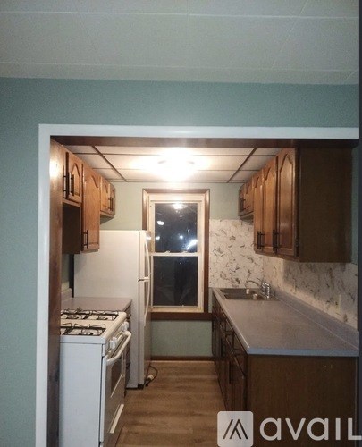 A kitchen with a white stove and wooden cabinets.