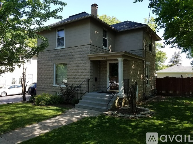 A house with a front yard and a car parked in the driveway.