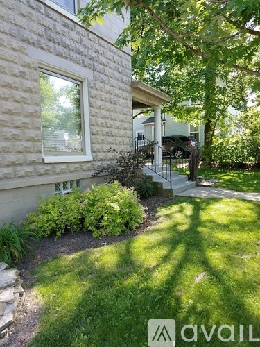 A house with a white window and a small garden in front.