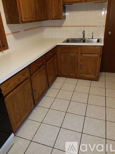 A kitchen with wooden cabinets and a white countertop.