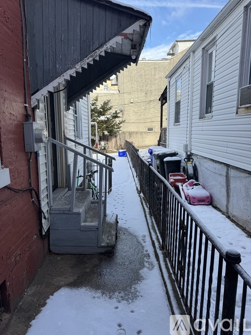 A small outdoor stairway with a black railing.