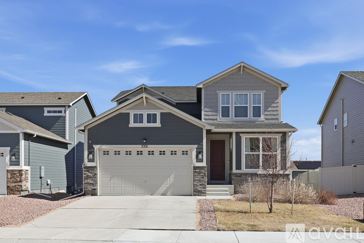 A two-story house with a garage is situated in a residential area.