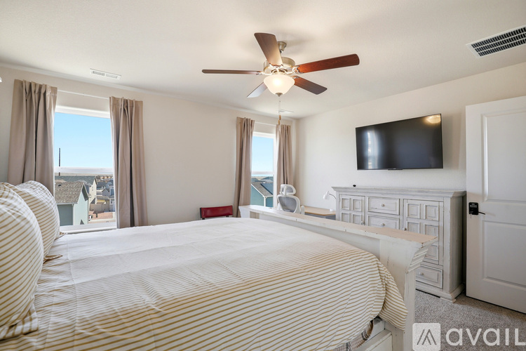 A bedroom with a large bed and a television mounted on the wall.