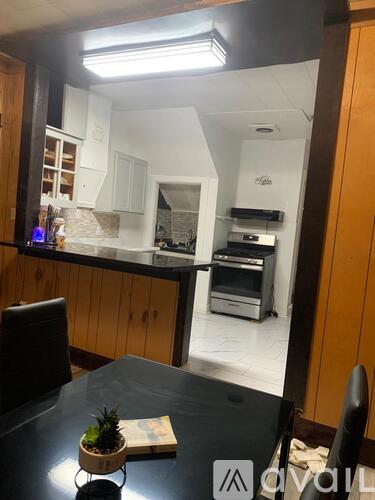 A kitchen with a black table and wooden cabinets.