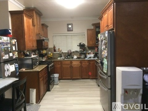 A kitchen with wooden cabinets and a black fridge.