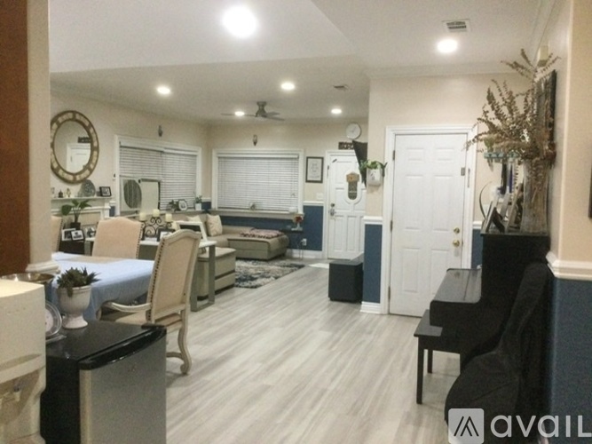 A living room with a piano and a dining area in the background.