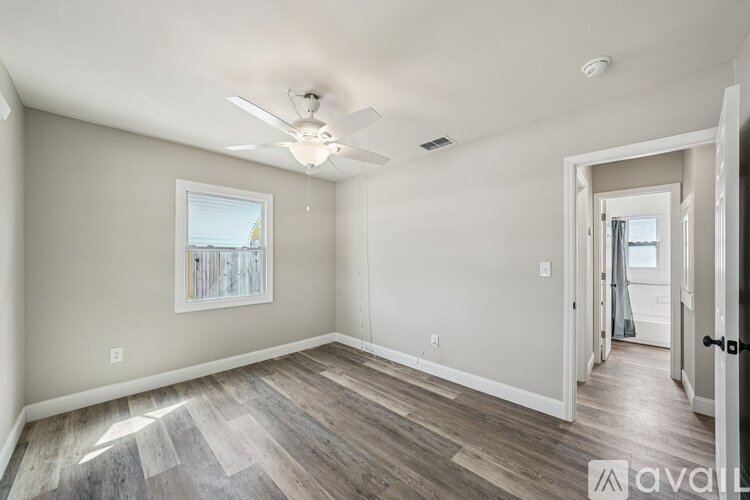 A spacious room with a ceiling fan and a window.