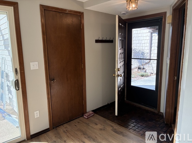 A room with a wooden door and a black door with a glass window.
