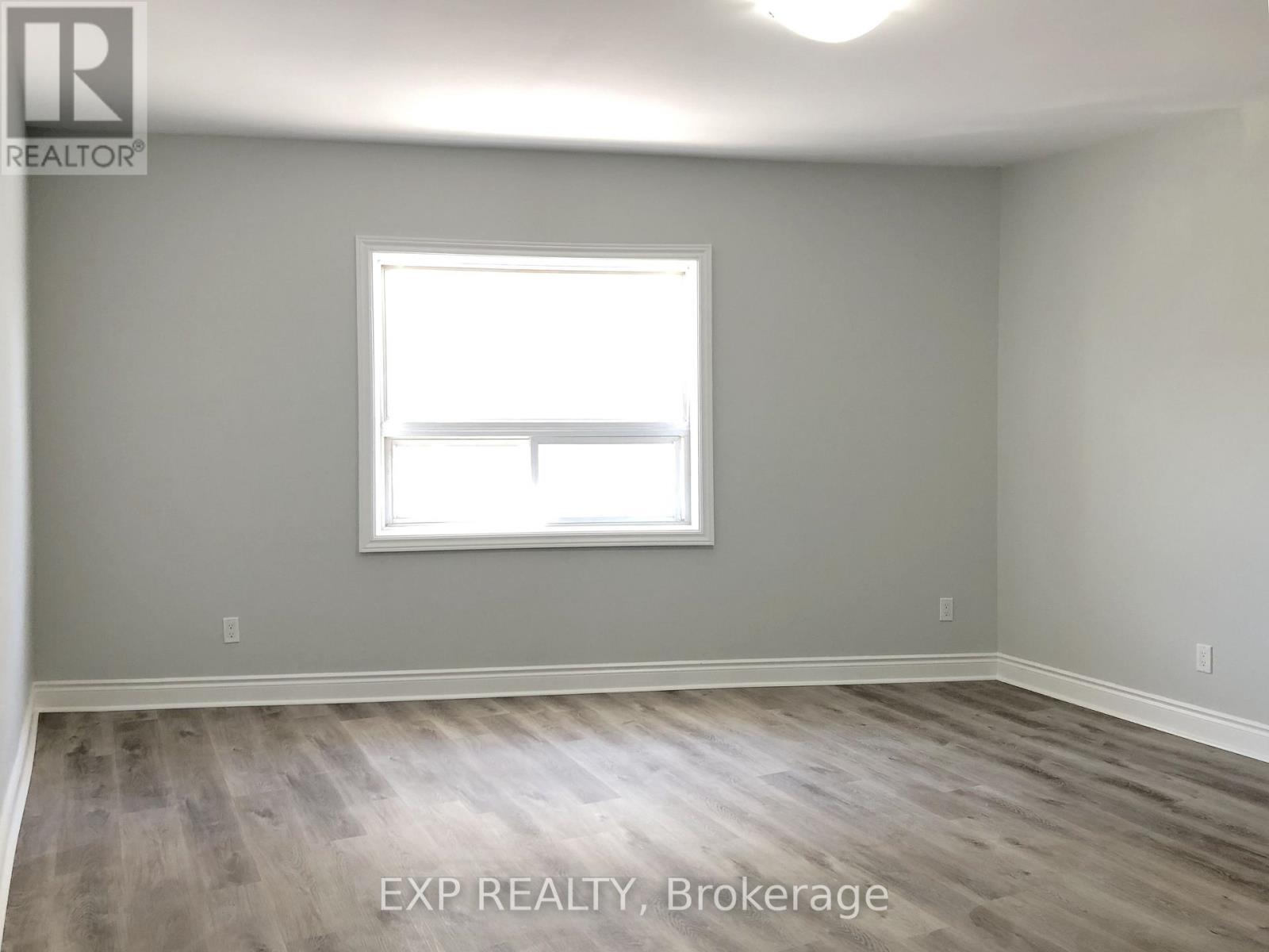 A room with a window and wooden flooring.