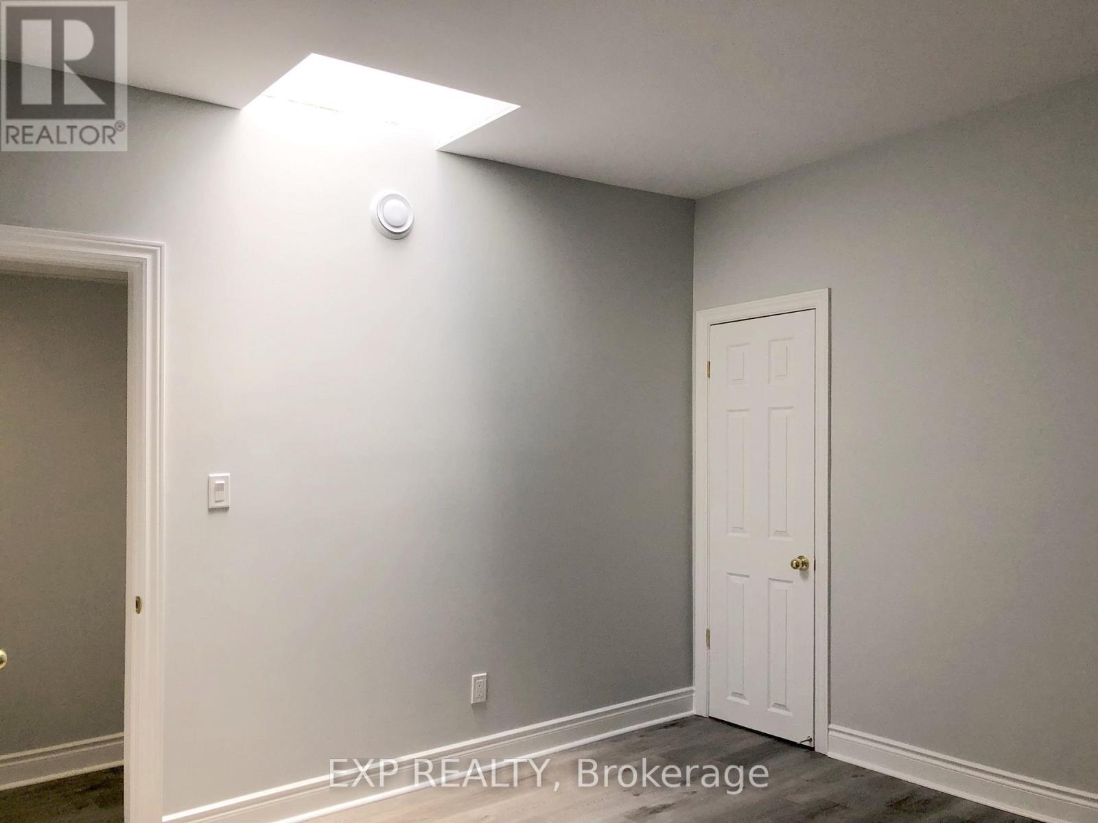 A room with a white door and a light on the wall.