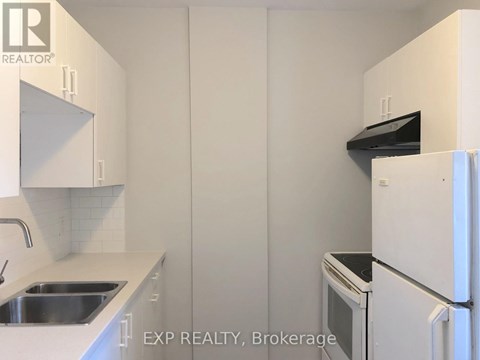 A kitchen with white cabinets and appliances.