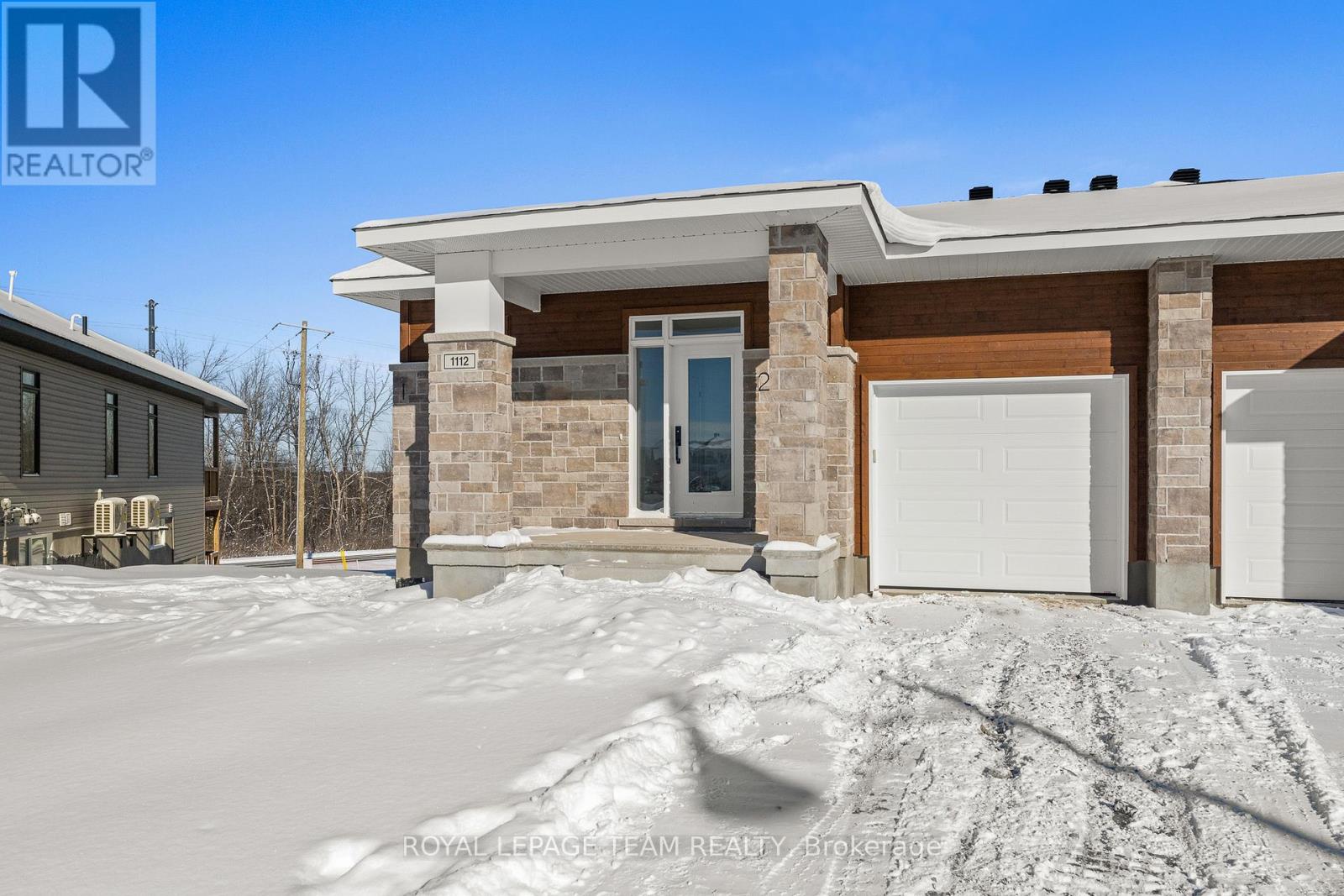 A house with a blue sky and snow on the ground.