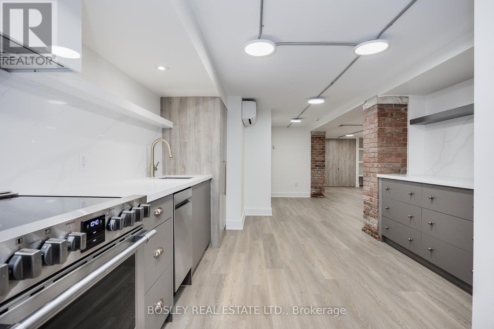 A modern kitchen with a stainless steel stove and wooden flooring.
