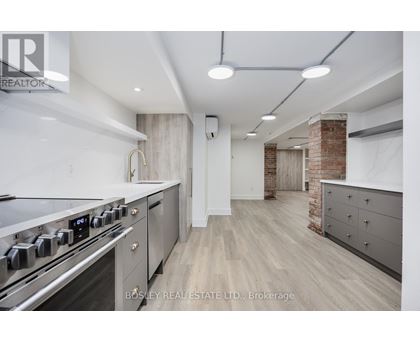 A modern kitchen with a stainless steel stove and wooden flooring.