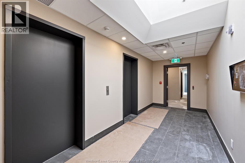 A hallway with a black door on the left and a wooden door on the right.