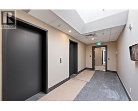 A hallway with a black door on the left and a wooden door on the right.