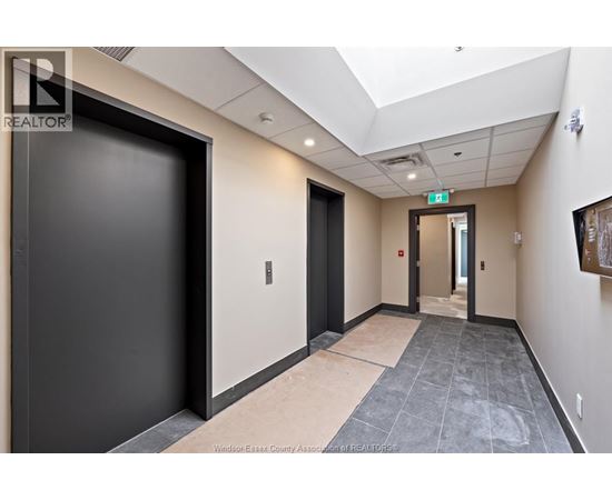 A hallway with a black door on the left and a wooden door on the right.