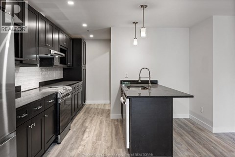 A modern kitchen with dark wood cabinets and a center island.