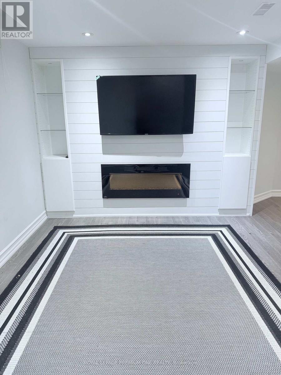 A modern living room with a fireplace and a flat screen TV mounted on the wall.