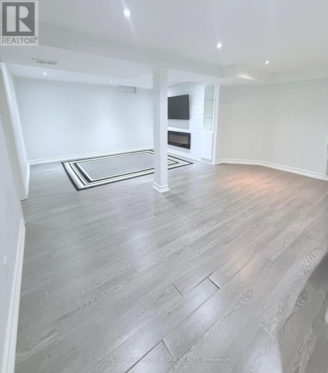 A spacious room with a grey floor and a black and white rug.