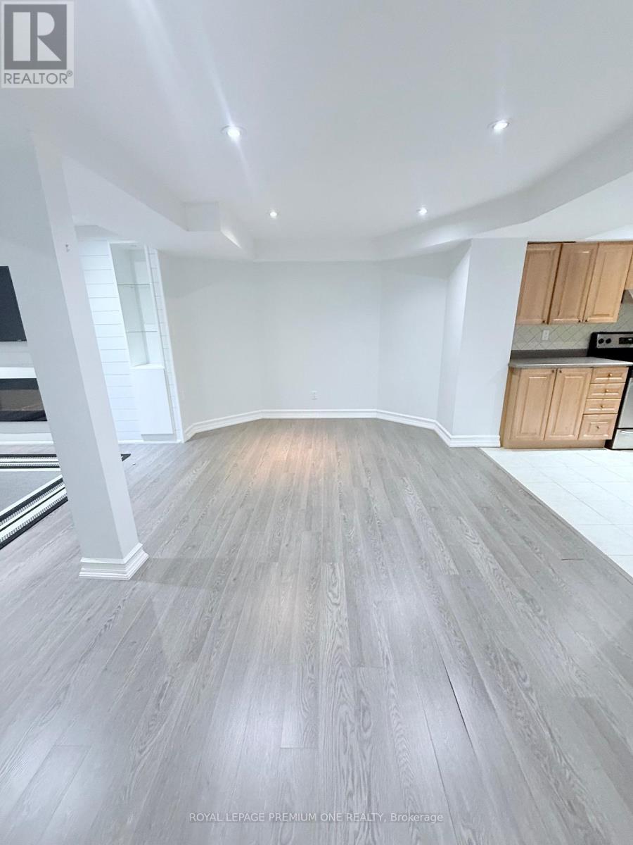 A spacious room with wooden flooring and white walls.