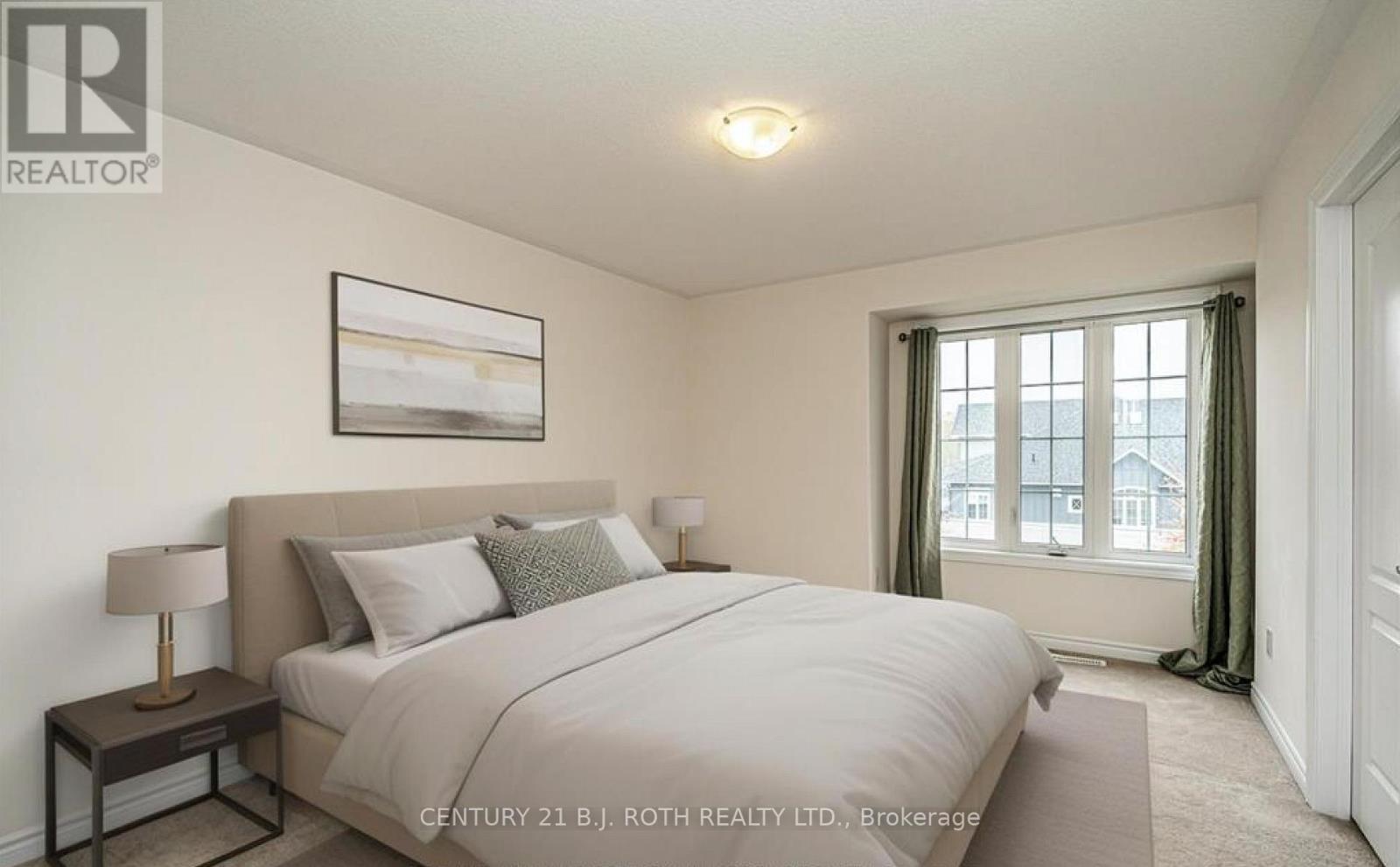 A bedroom with a large bed and a painting on the wall.