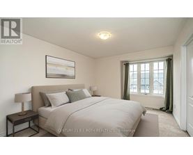 A bedroom with a large bed and a painting on the wall.
