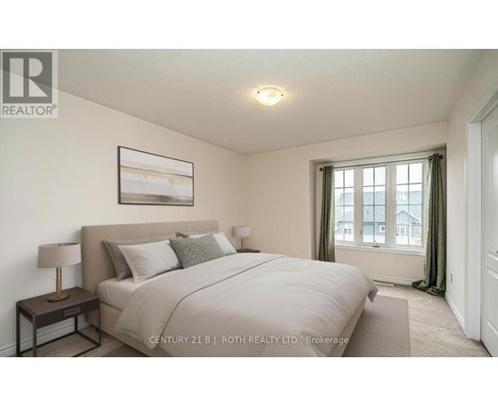 A bedroom with a large bed and a painting on the wall.