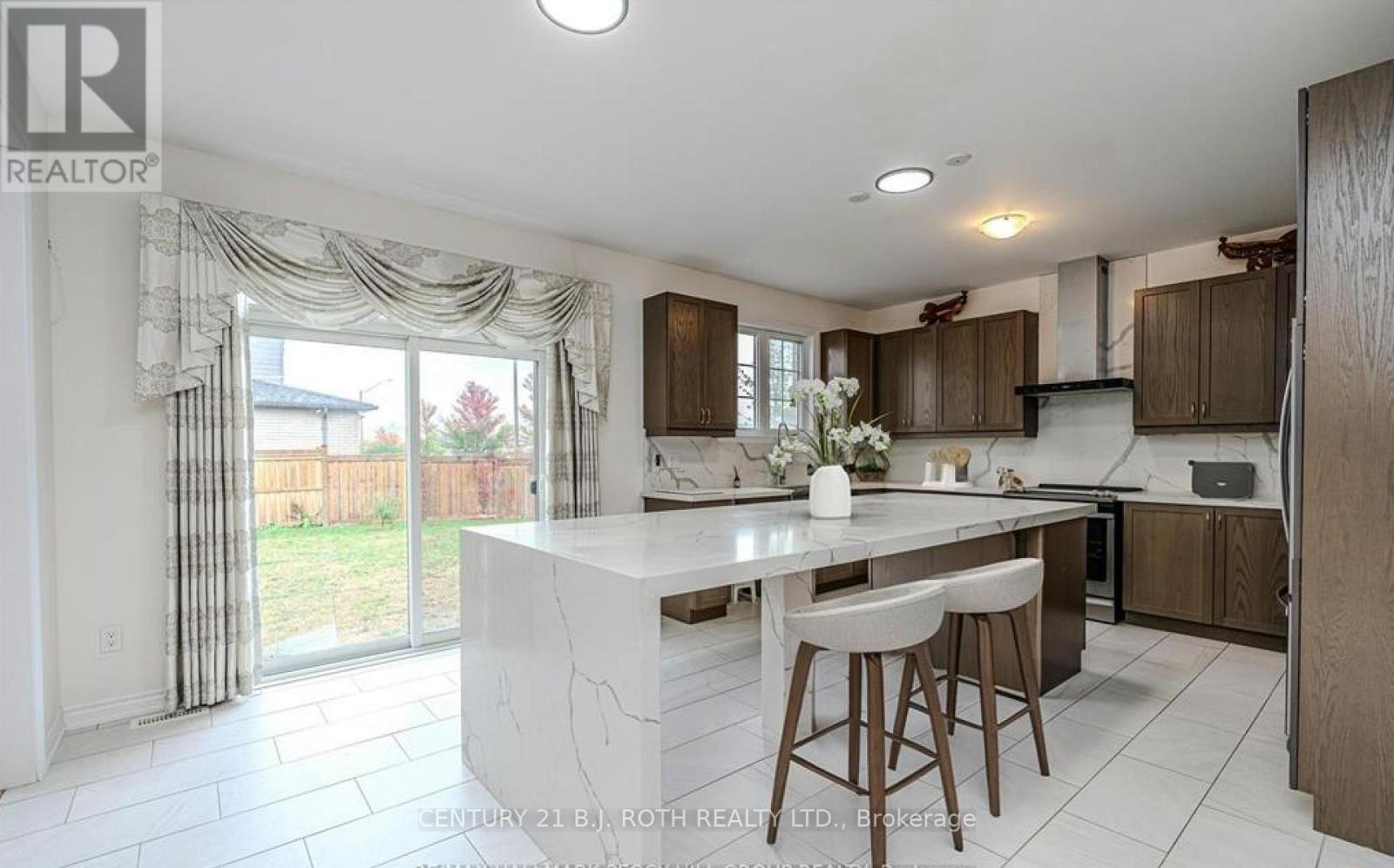 A kitchen with a white island and bar stools.