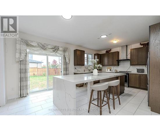 A kitchen with a white island and bar stools.