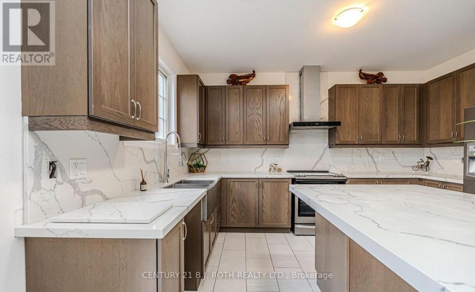 A kitchen with wooden cabinets and marble countertops.