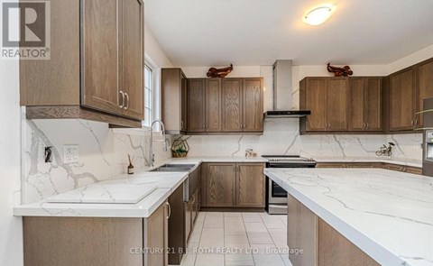 A kitchen with wooden cabinets and marble countertops.