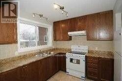 A kitchen with brown cabinets and a white dishwasher.