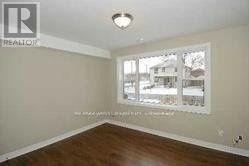 A room with a window and wooden floors.