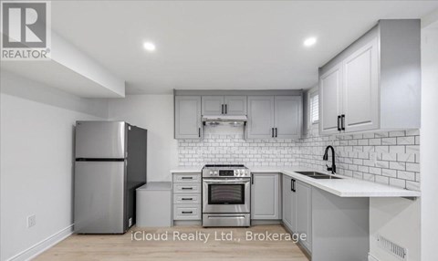 A modern kitchen with stainless steel appliances and white cabinetry.