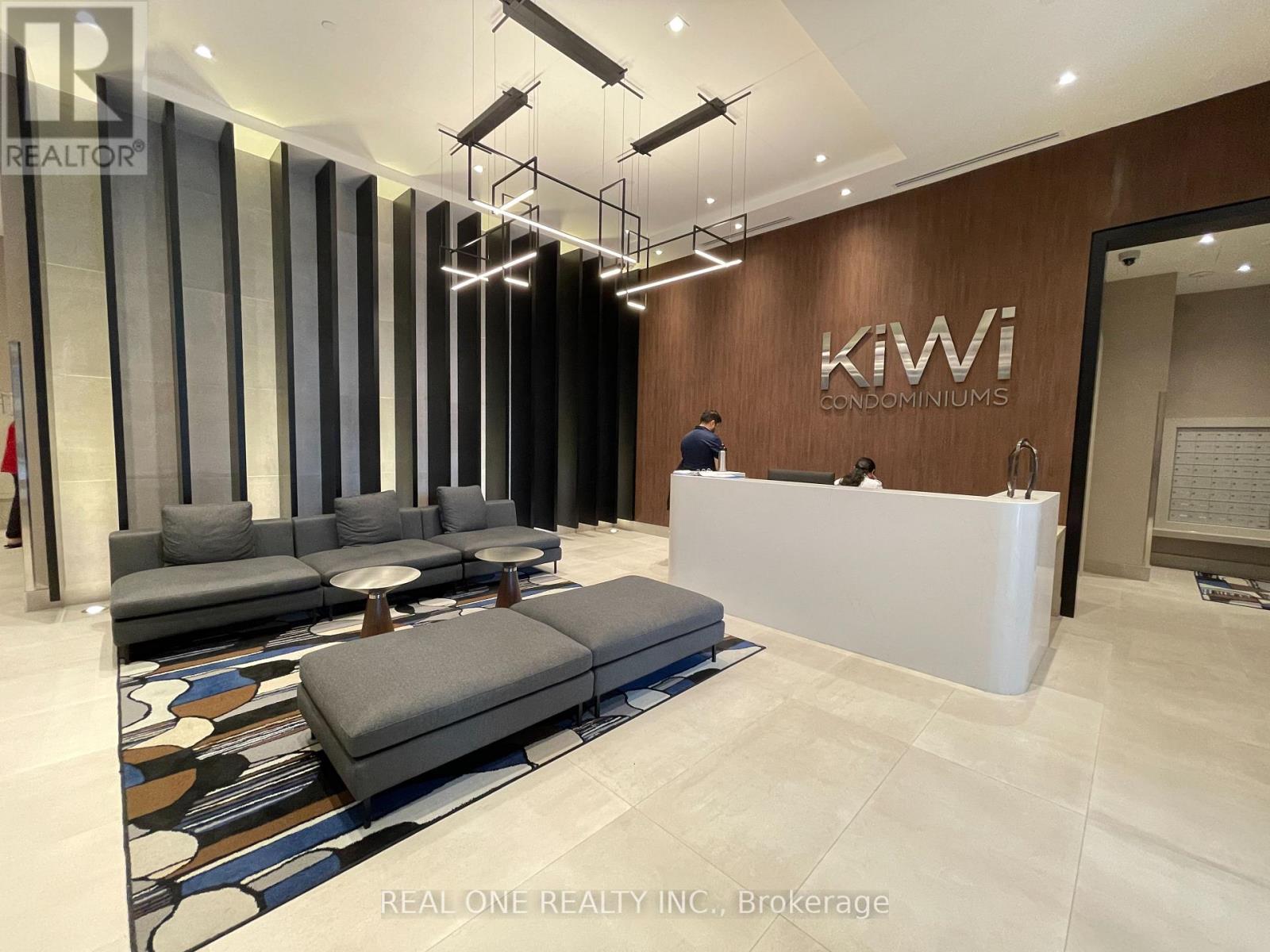 A reception area with a white reception desk and a man standing behind it.