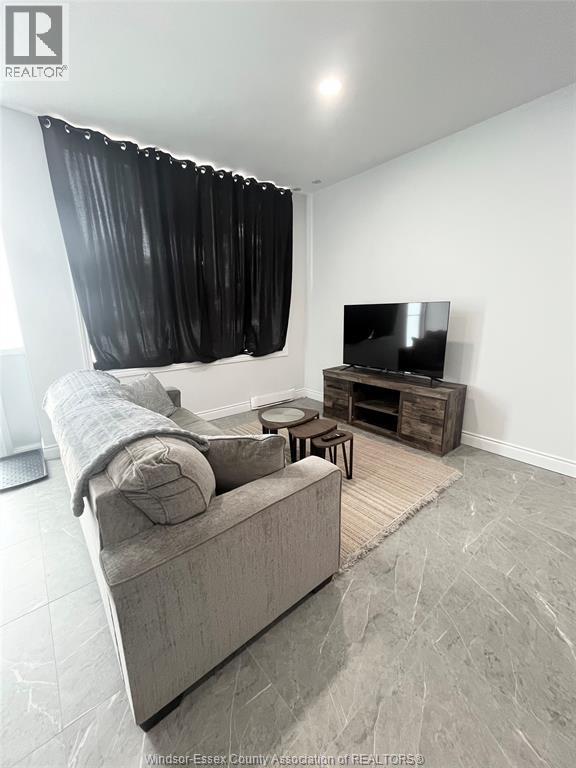 A living room with a grey couch, a television, and a wooden coffee table.