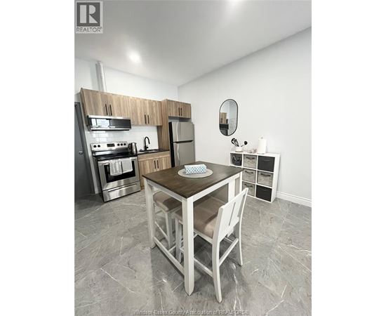 A kitchen with a table and chairs in the middle of the room.
