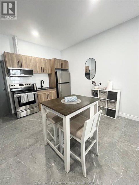 A kitchen with a table and chairs in the middle of the room.