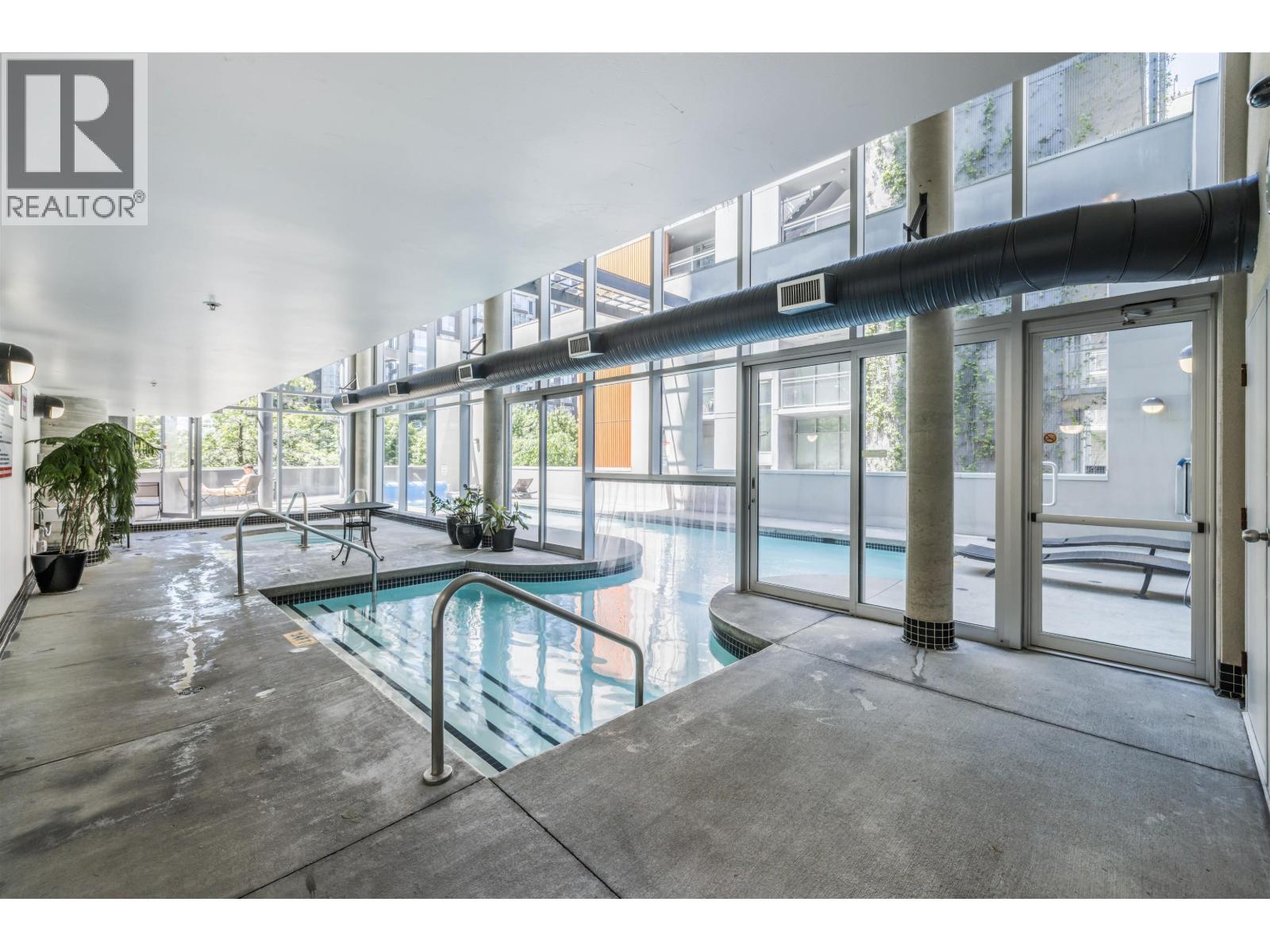 A pool area with a glass wall and a pool table.