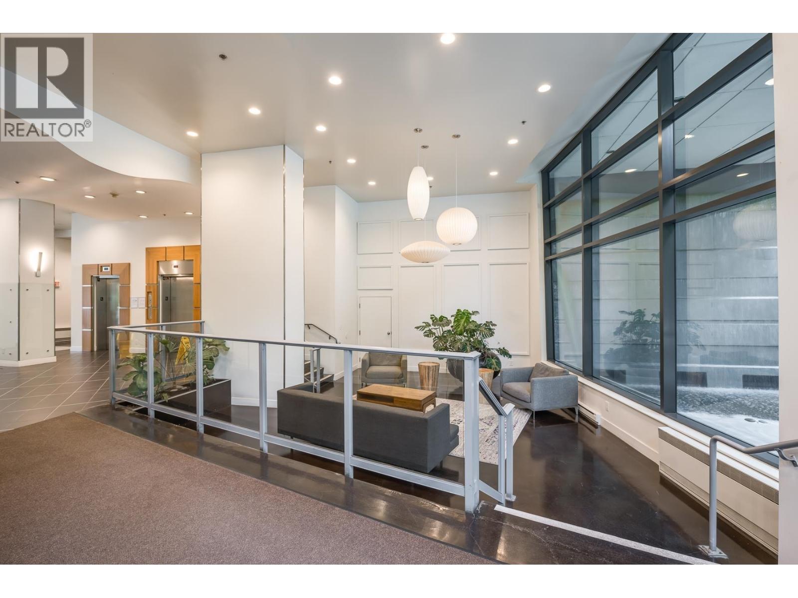 A spacious office lobby with a glass railing and a large window.