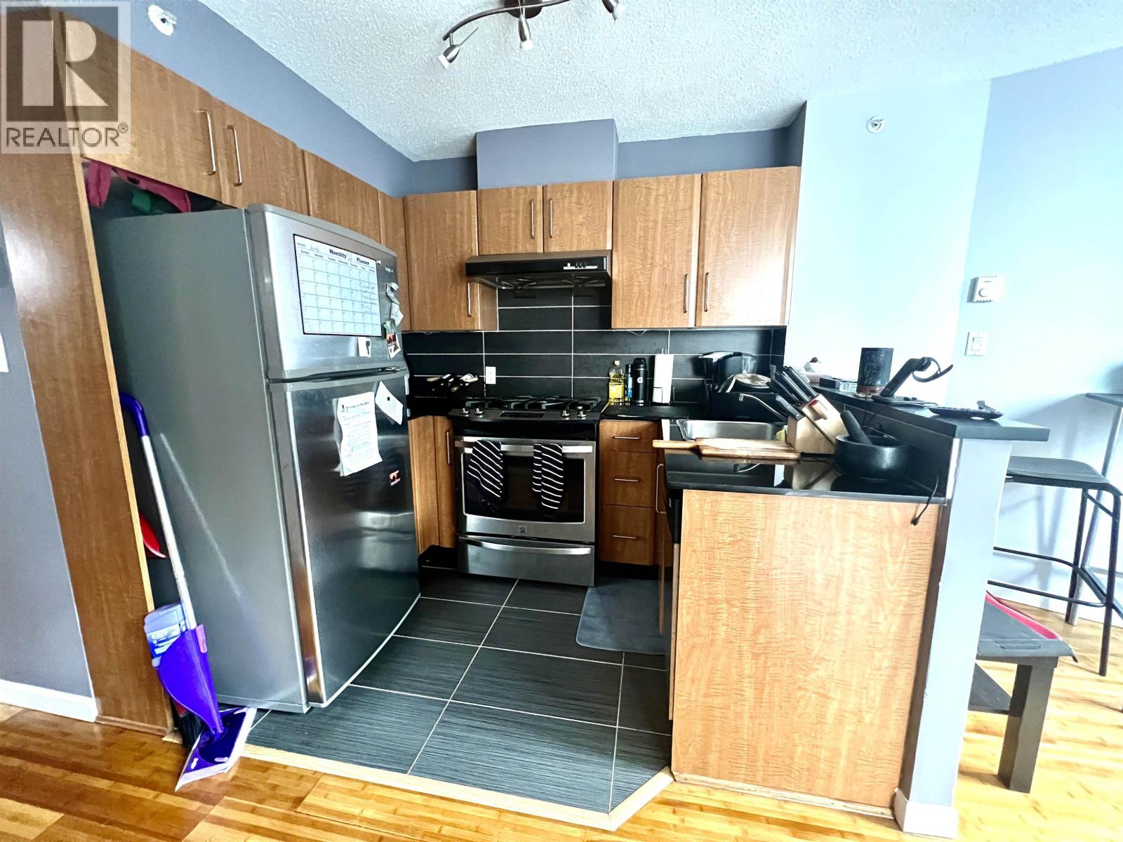 A kitchen with a refrigerator and oven.