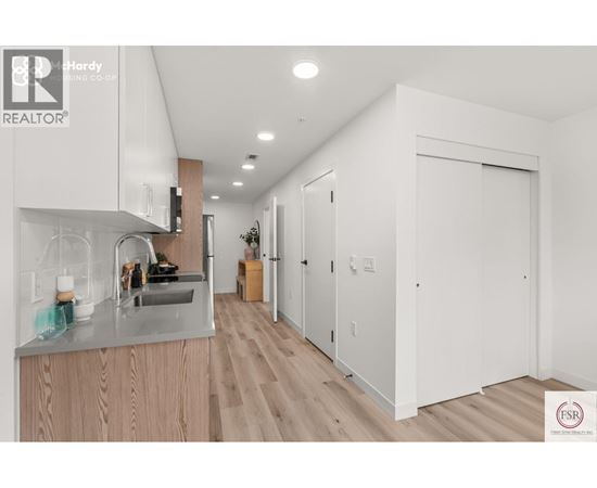A modern kitchen with wooden cabinets and a stainless steel sink.