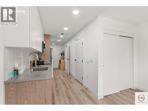 A modern kitchen with wooden cabinets and a stainless steel sink.
