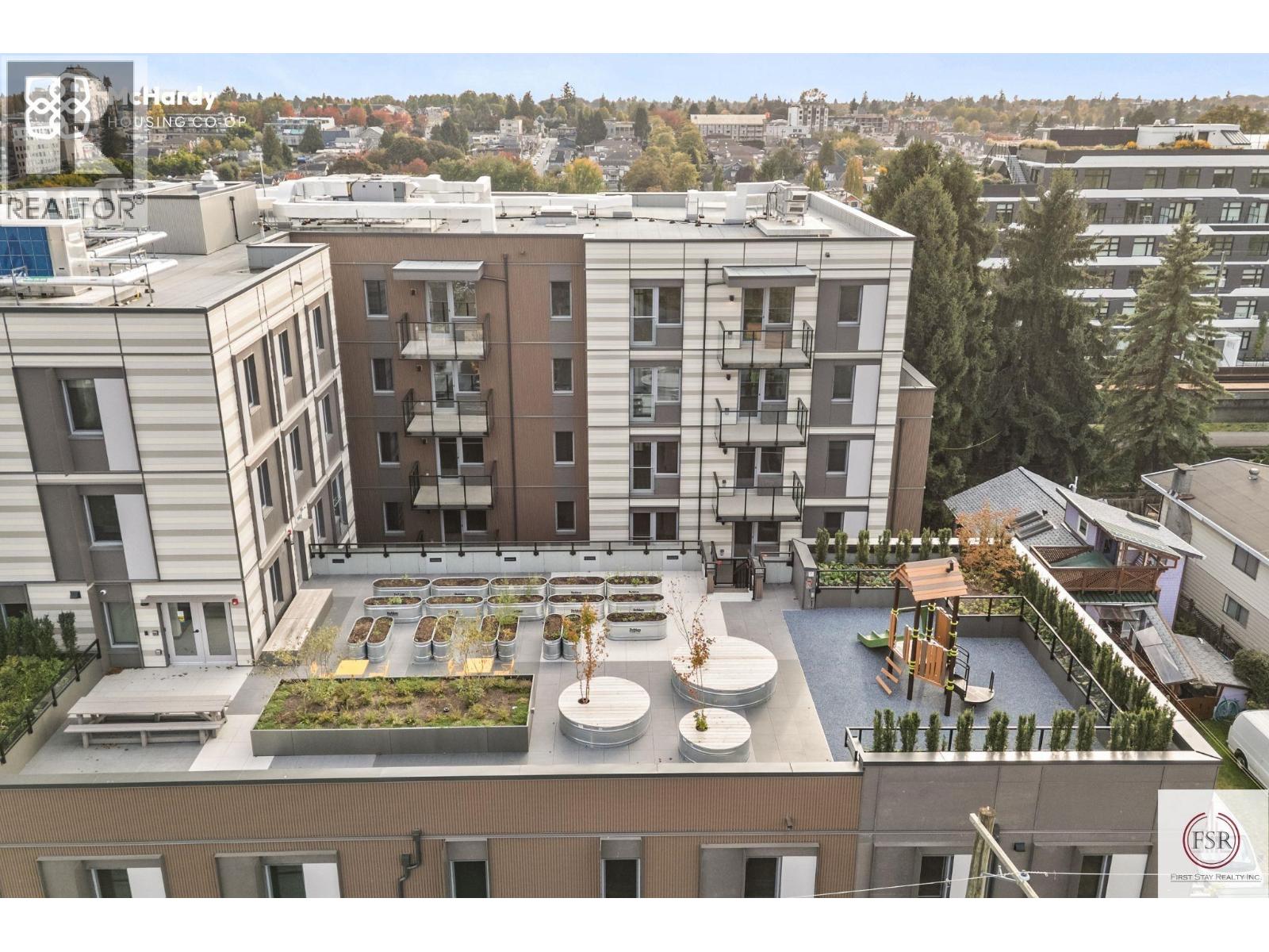 A rooftop garden is surrounded by apartment buildings.