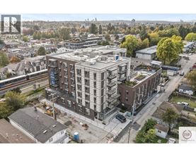 A construction site with a building under construction in the foreground and a residential area in the background.