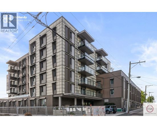 A multi-story residential building under construction with a clear sky in the background.
