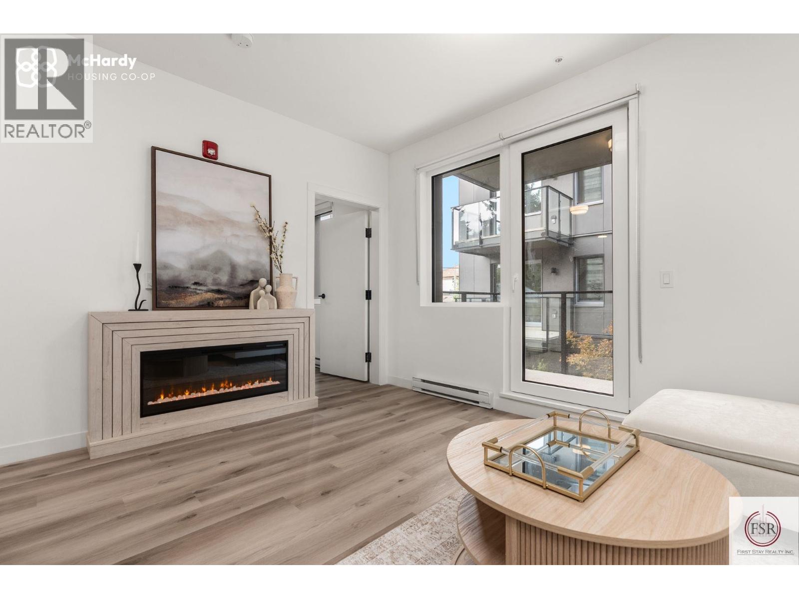 A modern living room with a fireplace and a painting on the wall.